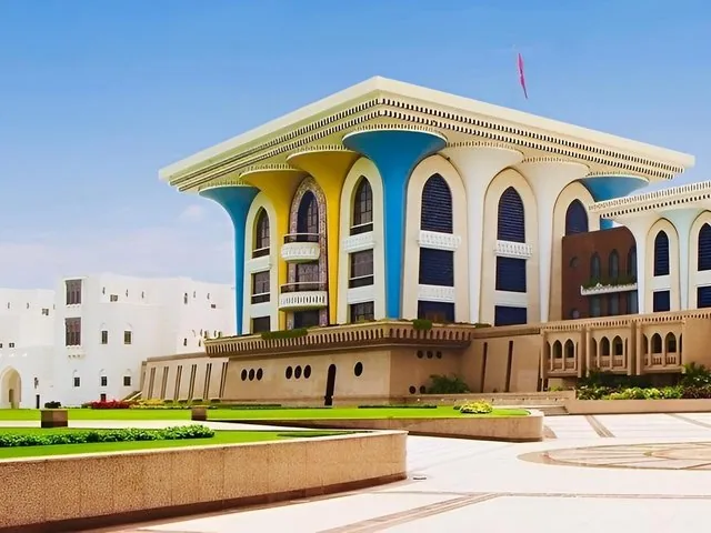The distinctive blue and gold facade of Al Alam Palace during the day.